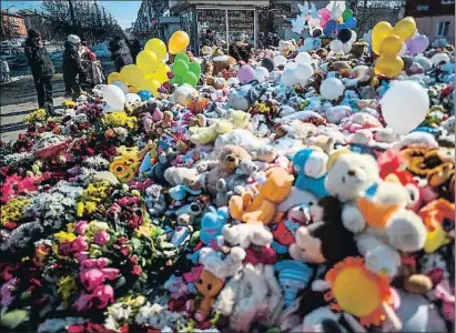  ?? DMITRY SEREBRYAKO­V / AFP ?? Flores, globos y peluches en Kémerovo para recordar a los 64 muertos en el incendio; 41 eran niños