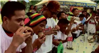  ?? MICHAEL B. JAUCIAN ?? MEN line up in the “kalamay”-eating contest of the Pulang-Angui Festival on June 28. Kalamay is made of hardened sugarcane juice and coconut milk molded in half of a coconut shell.