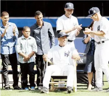  ??  ?? MARIANO RIVERA es todo sonrisas mientras prueba una sillón hecho con bates que le fue obsequiado por los Yankees. Joe Girardi, Derek Jeter y los hijos del taponero se disfrutan el momento.