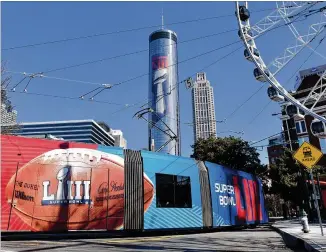  ?? HYOSUB SHIN / HSHIN@AJC.COM ?? An Atlanta Streetcar train displays a Super Bowl LIII advertisem­ent near Centennial Olympic Park in downtown Atlanta on Wednesday. Atlanta faces a test on Super Bowl Sunday and the question with two weeks to go before the big game is this: Is the city ready? The city budgeted some $10 million last year for police, fire and other items to assist with the big game.