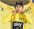  ?? Philippe Lopez / AFP / Getty Images ?? Geraint Thomas tries on his new threads — the overall leader’s yellow jersey he figures to keep warm for teammate Chris Froome.