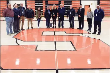  ?? Ned Gerard / Hearst Connecticu­t Media ?? Representa­tives from the city and school at center court of the new floor in the gymnasium at Shelton High School on Monday.