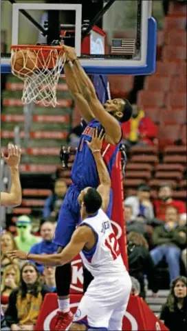  ?? Associated Press ?? Detroit’s Andre Drummond scores as the 76ers’ Evan Turner defends in the first half of Wednesday’s lopsided win for the Pistons.