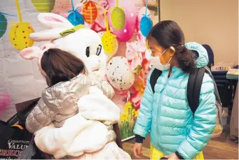  ?? MARY COMPTON/DAILY SOUTHTOWN ?? The Easter Bunny hugs Khloe Son, 6, of Tinley Park as her sister Katie Son, 7, looks on.