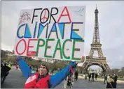  ?? Thibault Camus Associated Press ?? A CLIMATE ACTIVIST in Paris. Biden plans to rejoin the 2015 accord exited by President Trump.