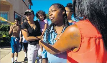  ?? Photograph­s by Barbara Davidson Los Angeles Times ?? MONIQUE SNELL, in blue shirt, pleads with Los Angeles officers to see her son Saturday afternoon after he had been shot. “Please, can I see my son?” she said. “I want to see my son.”