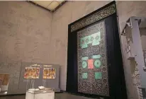  ??  ?? Keys of the Kaaba (box) and an Egyptian-made Kiswa (wall), the black silk cloth covering it, are displayed at the Museum of Egyptian Civilizati­on (NMEC).