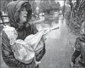  ?? Mark Boster For The Times ?? TANYA MORGAN of Modjeska Canyon carries sandbags to her backyard during a downpour Thursday. Another mild storm is expected later this week.