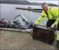  ?? FOTO: ÅSE ASTRI BAKKA ?? Naturforva­lter Stig Alfred Eikeland baerer i land en gammel TV som ble funnet på havbunnen.