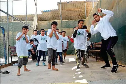  ??  ?? Arrivé en 2013 dans le camp Zaatari, Ali (à dr.) est devenu un des éducateurs de l’organisati­on Peace and Sport.