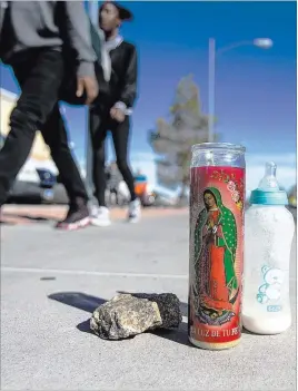  ?? Benjamin Hager ?? Las Vegas Review-journal People walk by a makeshift memorial Tuesday near East Katie Avenue and South Maryland Parkway. A family of four was struck in the crosswalk there Monday night, leaving a 4-year-old boy dead.