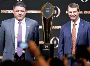  ?? AP Photo/ Chris Carlson ?? ■ LSU head coach Ed Orgeron, left, and Clemson head coach Dabo Swinney pose with the trophy Sunday after a news conference for the College Football Playoff national championsh­ip game in New Orleans.