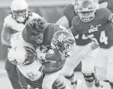  ?? Elizabeth Conley / Houston Chronicle ?? Rice Owls wide receiver Cameron Montgomery is taken down and separated from his helmet by FIU linebacker Anthony Wint (53) at Rice Stadium on Saturday.