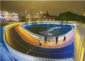  ??  ?? Joggers exercise after dinner along the riverfront walkway near Dongchang Road in Pudong. — IC