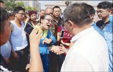  ?? EPA ?? Angry families confront an officer, demanding informatio­n about their missing relatives after huge explosions rocked the port city of Tianjin in China Friday.