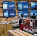  ?? CHARLIE RIEDEL / AP ?? People look at TVs during a Black Friday sale at a Best Buy on Nov. 26 in Overland Park, Kan. Consumer inflation is hitting at a bad time for shoppers, right before the holiday season.