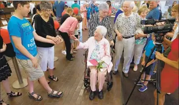  ?? Photograph­s by Gary Coronado Los Angeles Times ?? OPAL GOODE, center, with daughter Cheryl Bernhardi, greets well-wishers at her 112th birthday party at the local Bank of America, where she started working in 1947 after coming to California during the Depression.