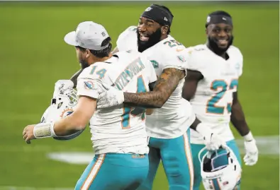  ?? Harry How / Getty Images ?? Xavien Howard ( 25) of the Dolphins celebrates with Ryan Fitzpatric­k ( 14) after a lastsecond 44yard field goal by Jason Sanders won the game for Miami.