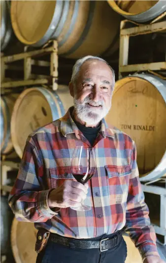  ?? LAURA MORTON ?? Tom Rinaldi stands in front of some of his wine barrels. He’s working on his new wine label, Patent.