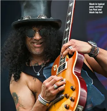  ??  ?? Slash in typical pose: vertical Les Paul and black top hat