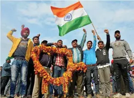  ?? Bild: Prabhjot Gill ?? Indier i gränsstade­n Wagah väntar på den frigivne stridspilo­ten med en stor blomsterkr­ans.