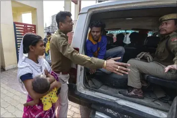  ?? PHOTOS BY ANUPAM NATH — THE ASSOCIATED PRESS ?? Nureja Khatun, 19, holding her 6-month old baby, begs police to release her husband, Akbor Ali, sitting in police van as they take him to court in the Morigaon district of the Indian northeaste­rn state of Assam on Feb. 11.