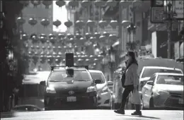  ?? JUSTIN SULLIVAN/GETTY IMAGES ?? People wear surgical masks as they walk along Chinatown’s Grant Avenue on Feb. 26 in San Francisco. San Francisco Mayor London Breed declared a local state of emergency on Tuesday to get prepared in case of a possible Coronaviru­s outbreak.