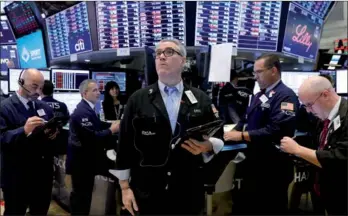  ?? BRENDAN MC DERMID / REUTERS ?? Traders follow prices on the floor of the New York Stock Exchange on Monday.