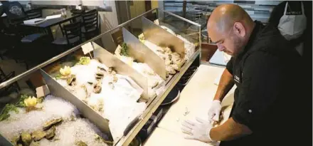  ?? CARLINE JEAN/SOUTH FLORIDA SUN SENTINELPH­OTOS ?? Chef Jovito Robledo of Coconuts restaurant in Fort Lauderdale sorts through oysters on Thursday. Coconuts gets its cold water oysters from Massachuse­tts, Virginia and Prince Edward Island. The restaurant is known for its safe shellfish preparatio­n.