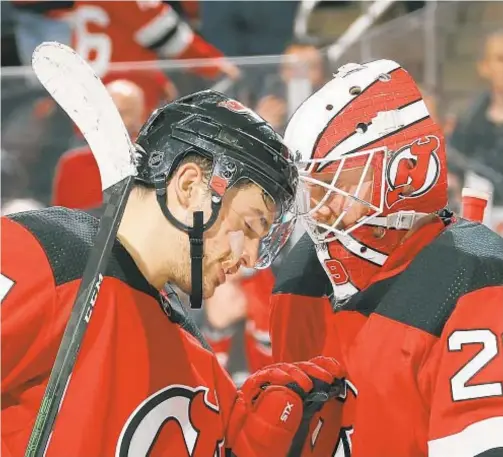  ?? GETTY ?? Miles Wood (l.) and Mackenzie Blackwood celebrate after victory over Ducks Wednesday night in Newark.