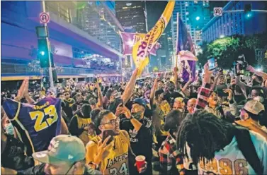  ??  ?? Cientos de aficionado­s de los Lakers celebran el título de su equipo en los alrededore­s del Staples Center.