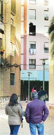  ?? MIQUEL GONZÁLEZ / SHOOTING ?? José, Paola y Francis miran con incredulid­ad el agujero de la placa que voló del reactor, a 3 km. Impactó contra el edificio y derrumbó el suelo del 3º que cayó y mató a Sergio Millán, vecino del 2º