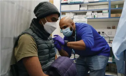  ?? ?? A nurse administer­s a Covid booster dose to a patient at a pharmacy in north London. Photograph: Gareth Fuller/PA