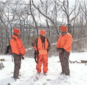  ?? PAUL A. SMITH/MILWAUKEE JOURNAL SENTINEL ?? Mark Schack (left) of Tomah and his son, Matthew Schack (right) of Fitchburg, talk with Will Kramer of Dodgeville after a morning hunt on land owned by Will’s parents, Kent and Amy Kramer, on opening day of the 2018 Wisconsin gun deer hunting season.