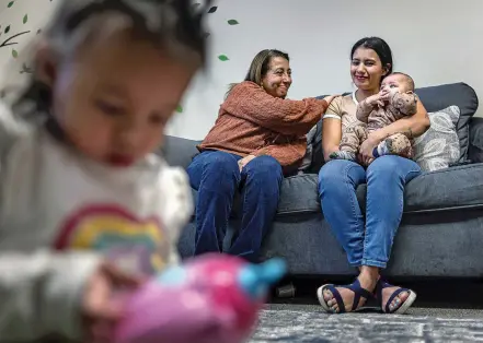  ?? PHOTOS BY JIM WEBER/THE NEW MEXICAN ?? ¡Que Cute! Program Manager Maribel Lemus, center, helps translate for Astrid Delgadillo, right, who immigrated to the U.S. with her young daughter, Valentina Giron, left and other children while she was pregnant with her son Jankel Giron as she was being housed in a shelter.