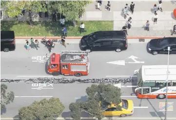  ??  ?? Spilled asphalt is seen on a major road in the centre of Taipei, Taiwan. — Reuters photos