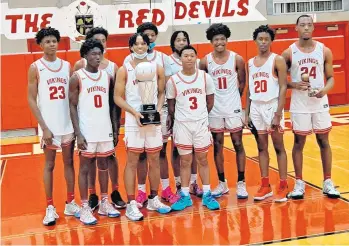  ?? STEVE MILLAR / DAILY SOUTHTOWN ?? Junior guard Nashawn Holmes holds the championsh­ip trophy as Homewood-Flossmoor celebrates its 62-44 win over Oswego East in the championsh­ip game of the Hinsdale Central Holiday Classic on Wednesday.