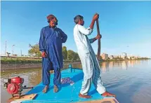  ?? AFP ?? Ghulam Akbar (left), a local fisherman and volunteer of the Indus river dolphins rescue team, stands on a boat during a monitoring routine along the Indus river.