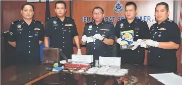  ??  ?? Kapit deputy police chief DSP Jame Reis (centre) and other senior police officers show the items confiscate­d from the raided premises.