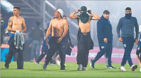  ?? TÉLAM ?? GASES. Los hinchas se cubren ante la emanación de gases tóxicos en plena cancha de Gimnasia. La oposición quiere avanzar contra Berni la semana que viene y culpa al gobernador bonaerense por el manejo político de la Policía Bonaerense.