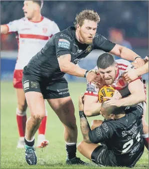  ??  ?? STAYING UP: Hull FC’s Scott Taylor, left, joins team-mates Sika Manu &amp; Danny Washbrook in trying to take down Hull KR’s Mitch Garbutt during last week’s derby opener in Super League.