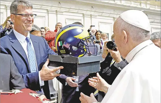  ?? GETTY ?? Jim Harbaugh presents Pope Francis with Michigan helmet on trip to Rome this spring and, back in the states, looks for big things from his Wolverines in 2017.