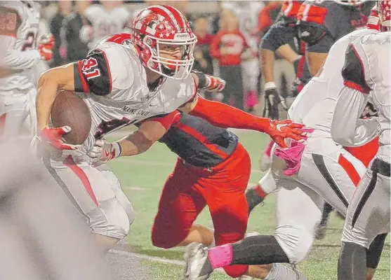  ?? | WORSOM ROBINSON/ FOR THE SUN- TIMES ?? Maine South’s Fotis Kokosiouli­s slips a tackle againstWes­t Aurora on Friday in Aurora. He rushed for 162 yards on 22 carries.