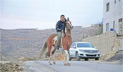  ?? — AP ?? RAMALLAH: In this Thursday, Jan 5, 2017 photo, Palestinia­n Hamza Hamad,16, rides his horse at his home, in the village of Silwad.