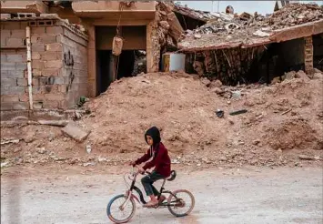  ?? Joao Silva / The New York Times ?? A child passes a building destroyed in 2016 as Iraqi fighters wrested control of Fallujah from the Islamic State. Much of the country bears the scars of two decades of violence.