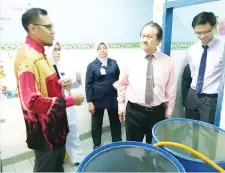  ??  ?? Wong (right) being briefed on the water shortage problem at Semporna Hospital. Also seen are the hospital water tanks that need to be filled up regularly.
