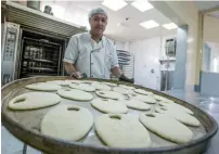  ?? Kunafa ?? READy To BAkE... bread is transferre­d to an oven for further processing at the kitchen of the sweet store.