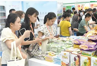  ?? XINHUA PHOTO ?? REAPING FRUITS
Visitors shop for Vietnamese commoditie­s at Nanning Internatio­nal Convention and Exhibition Center in Nanning, capital of Guangxi Zhuang Autonomous Region, on Sept. 18, 2023. China is seeking to step up its efforts to secure more free trade agreements in 2024.