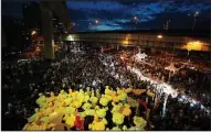  ?? (AP/Sakchai Lalit) ?? Inflatable yellow ducks, which have become good-humored symbols of resistance during anti-government rallies, are lifted over a crowd of protesters Friday in Bangkok. Video at arkansason­line.com/1128bangko­k/.