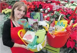  ?? JASON PAYNE/ PNG ?? GardenWork­s chief operating officer Leanne Johnson shows off a gardener’s Christmas trug packed with presents that would be enjoyed by novice and seasoned green thumbs alike.